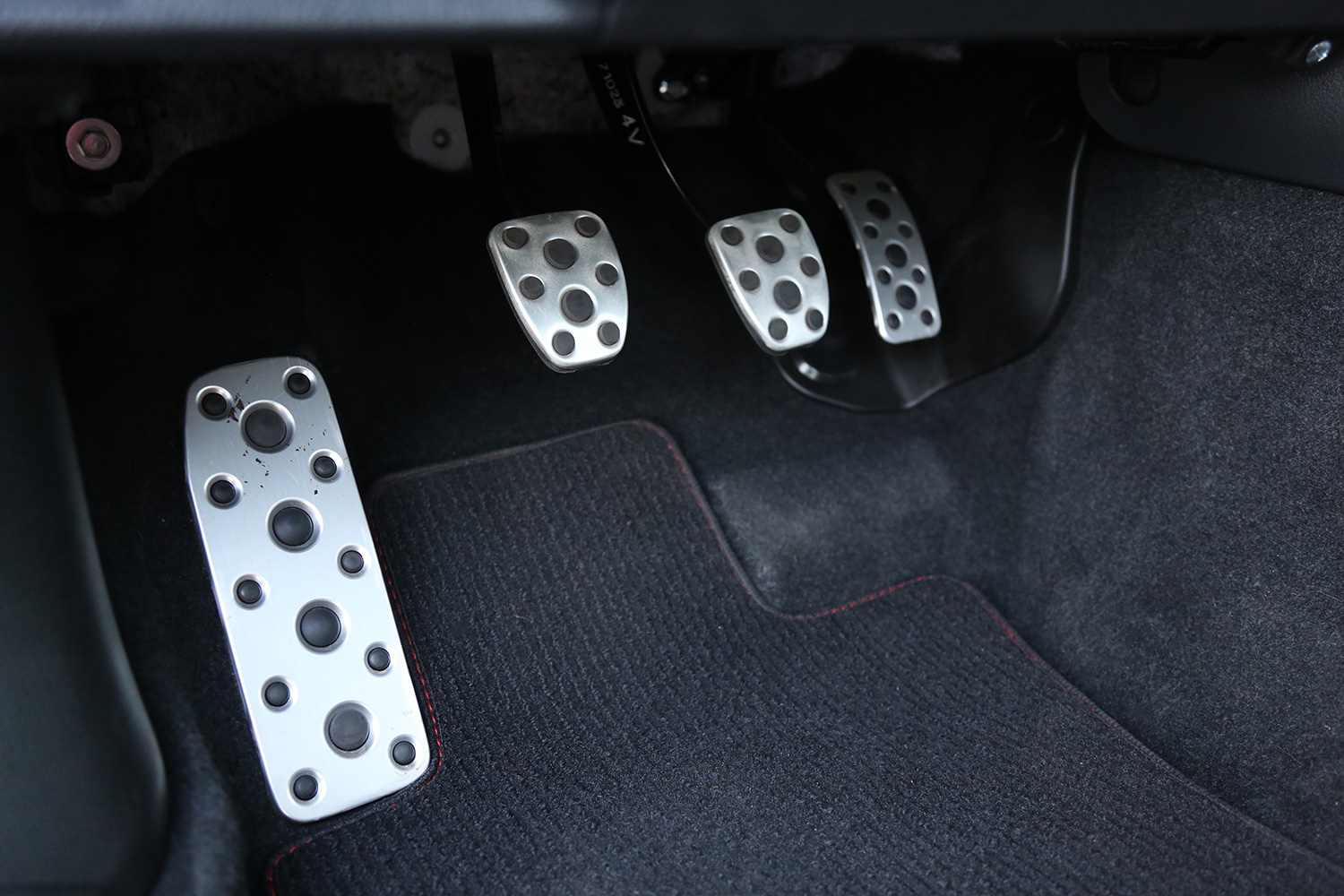 alt: Close-up view of the pedals in a manual transmission car