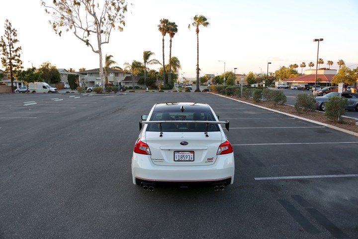 alt: A person driving a stick shift car on a road