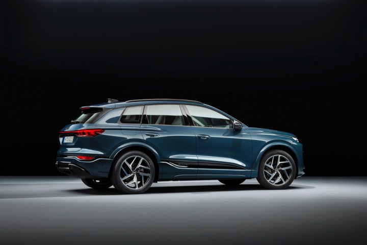 alt: Rear three-quarter view of the 2025 Audi Q6 e-tron, highlighting its sleek design and powerful stance.