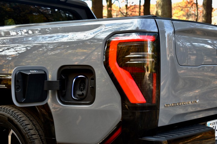 alt: Close-up of the 2024 GMC Sierra EV's charging port, ready for connection to a charging cable.