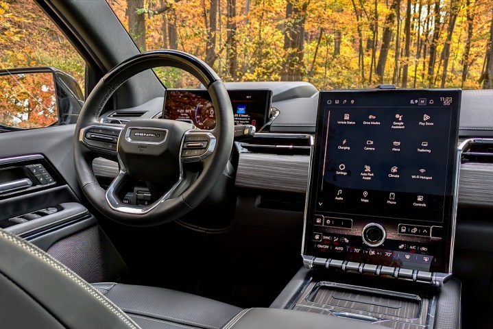 alt: Interior view of the 2024 GMC Sierra EV, showcasing the dashboard, infotainment screen, and steering wheel.