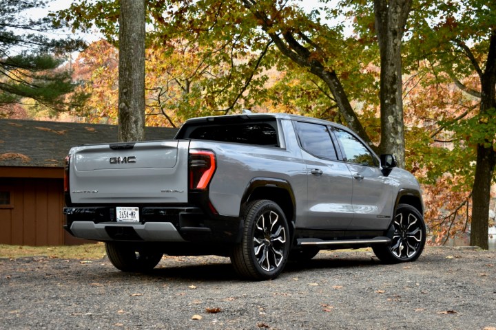 alt: Rear three-quarter view of the 2024 GMC Sierra EV showcasing its design and size.