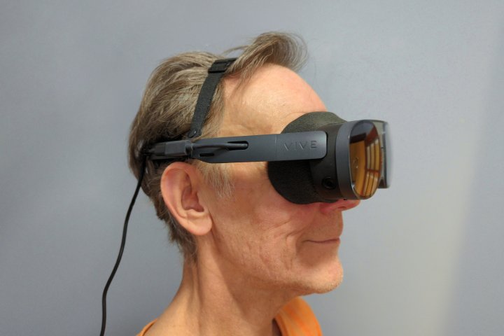 alt text: The HTC Vive XR Elite in glasses mode, using earpieces and a cross strap instead of the halo strap and battery.