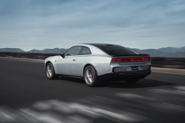 alt: Rear three quarter view of the 2024 Dodge Charger Daytona coupe, showcasing its taillights and rear design.