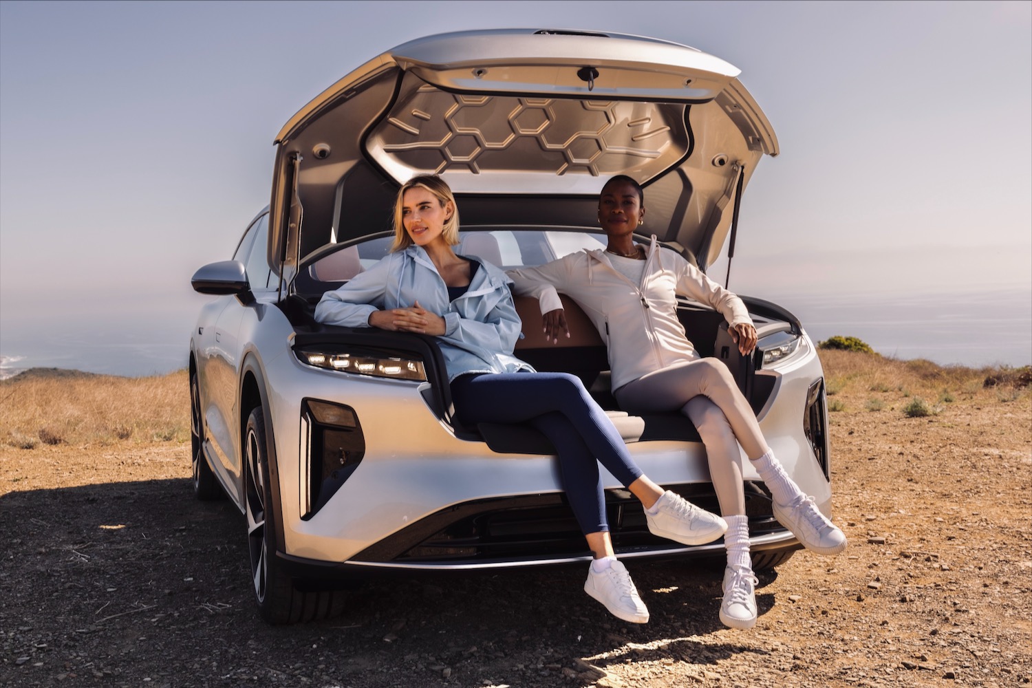 Two models sitting in a Lucid Gravity frunk.