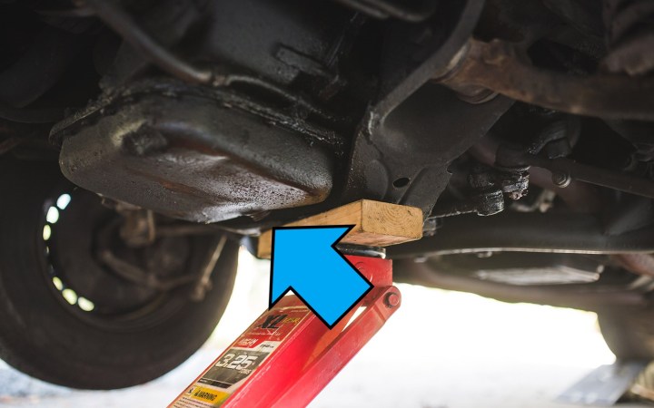 alt text: Locating the oil drain plug on a car