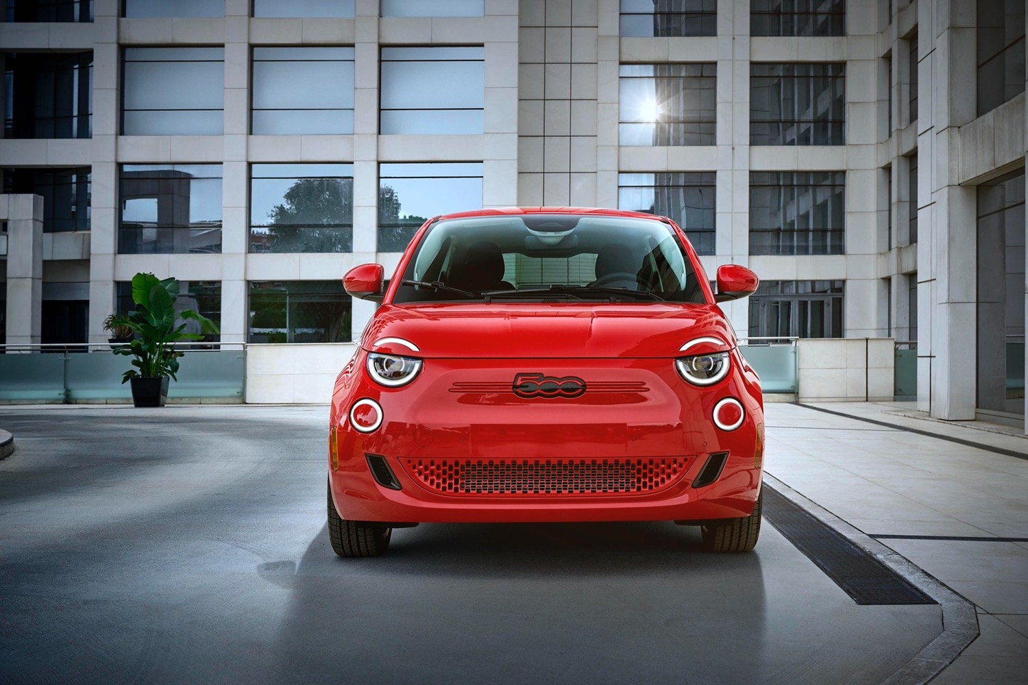 Alt text: A front view of the 2024 Fiat 500e highlighting its iconic round headlights and compact size.