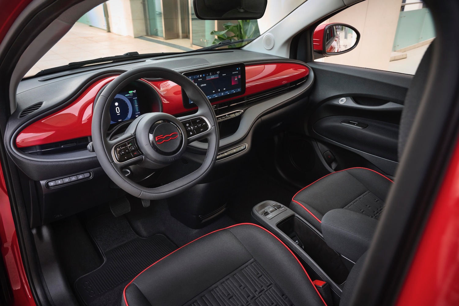 Alt text: The interior of the 2024 Fiat 500e showing the dashboard, steering wheel, and infotainment screen.