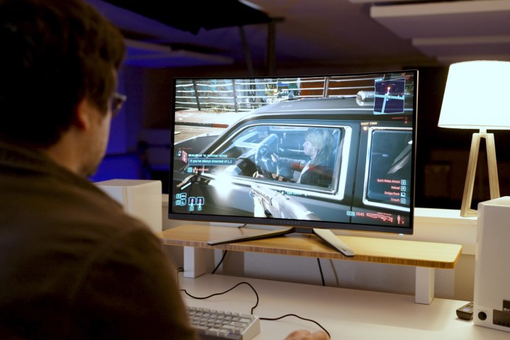 alt text: A scene from Cyberpunk 2077 displayed on the Alienware 32 QD-OLED, showcasing the monitor's ability to handle complex lighting and visual effects with impressive clarity and color accuracy.