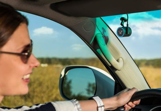 alt: The Garmin Speak, a small circular device mounted on a car windshield, provides Alexa and navigation features.