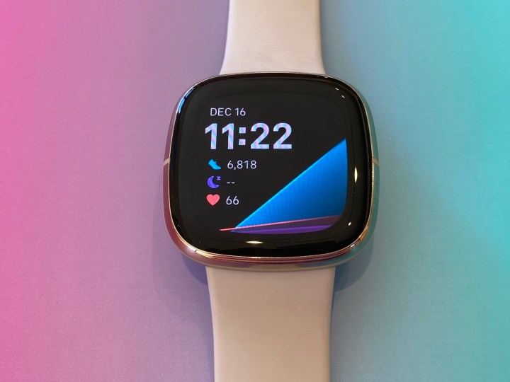 The Fitbit Sense smartwatch on a colorful background.