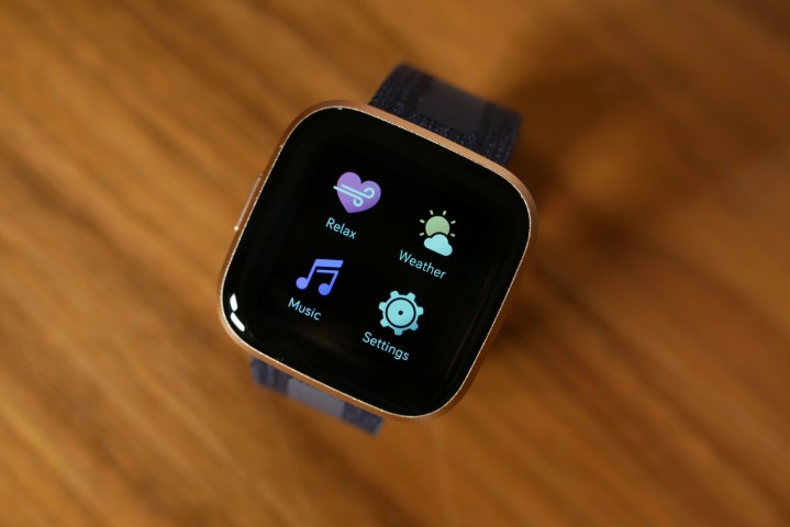 The Fitbit Versa 2 showing apps, while on a table.