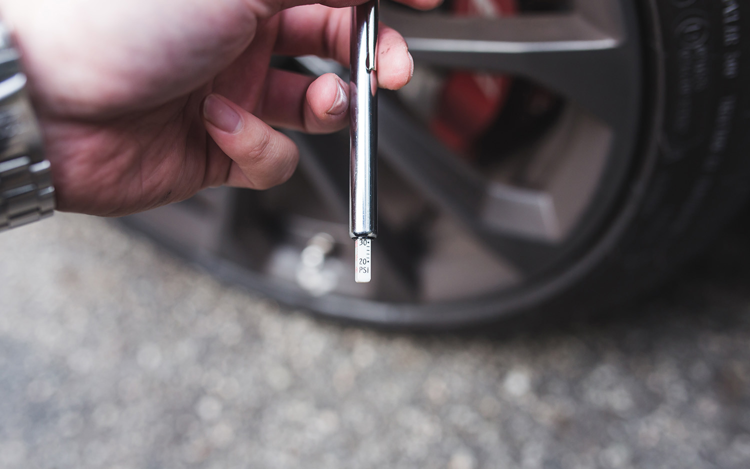 alt text: Reading the tire pressure on a gauge