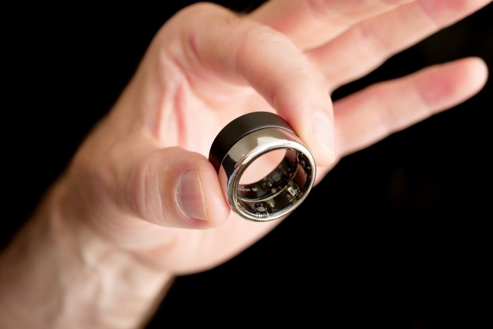 alt: The Oura Ring (silver) and Ultrahuman Ring Air (black) held in hand, emphasizing their size and wearability.