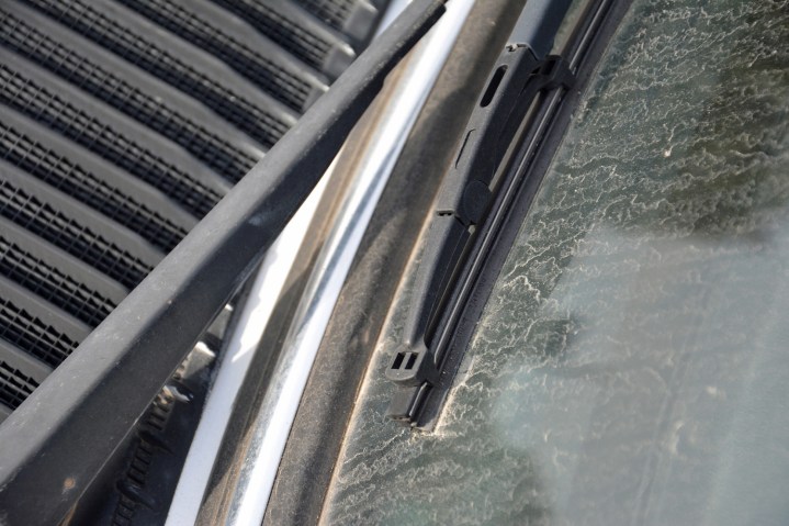 alt: Close-up of a car's windshield wipers in action