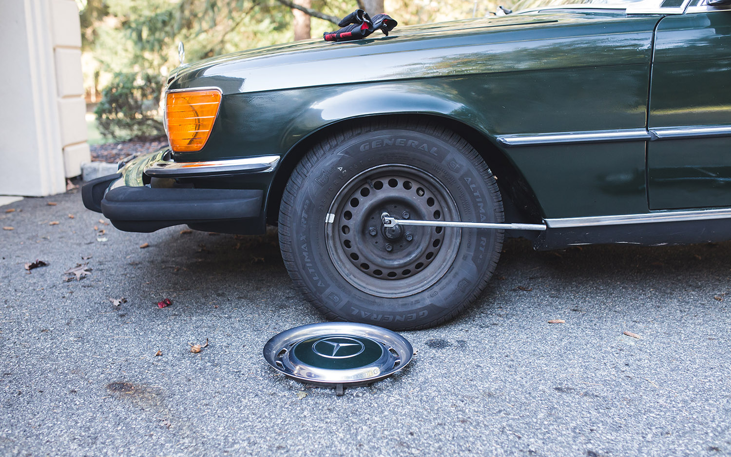 alt text: Person loosening lug nuts on a car wheel