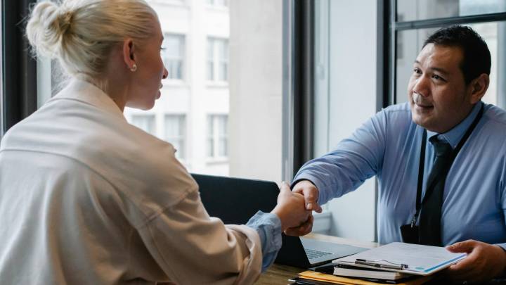 Alt: Two people shaking hands, symbolizing a successful job interview or agreement.