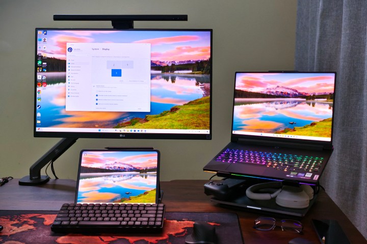 alt: A desk setup featuring a Lenovo laptop, LG monitor, and OnePlus Pad 2 as a secondary monitor.