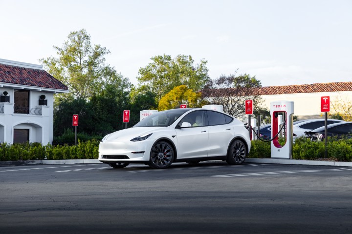 alt text: A white Tesla charging at a Supercharger station.