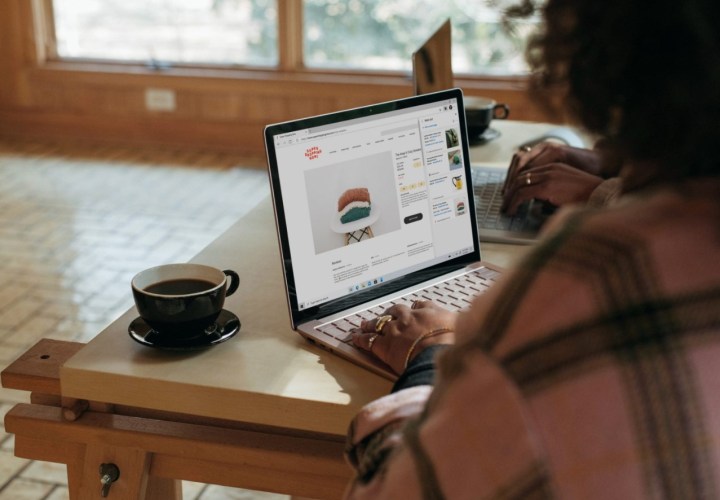 alt: A person using a laptop at a desk.