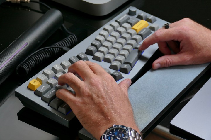 alt text: A person typing on a Keychron Q8 ergonomic mechanical keyboard. Ergonomic keyboards can improve typing comfort and reduce strain.