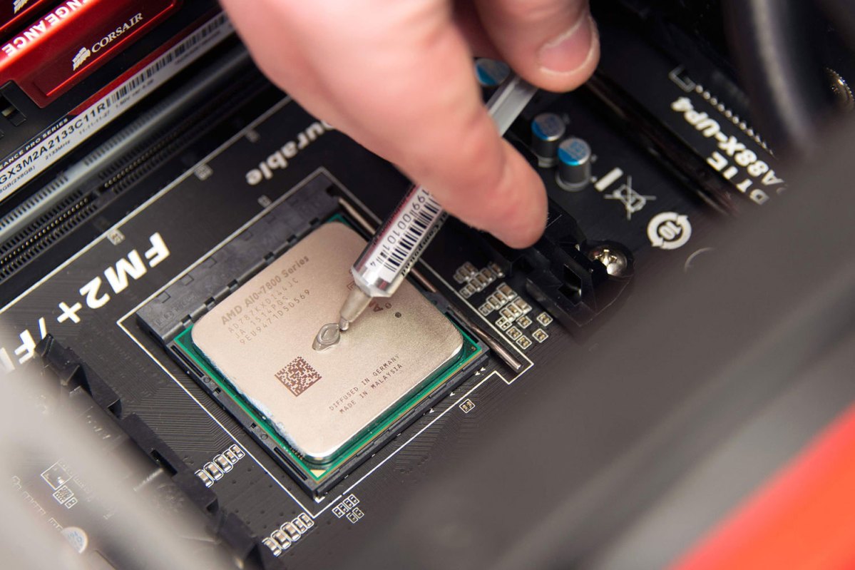 Alt: A close-up of thermal paste application on the AMD CPU.