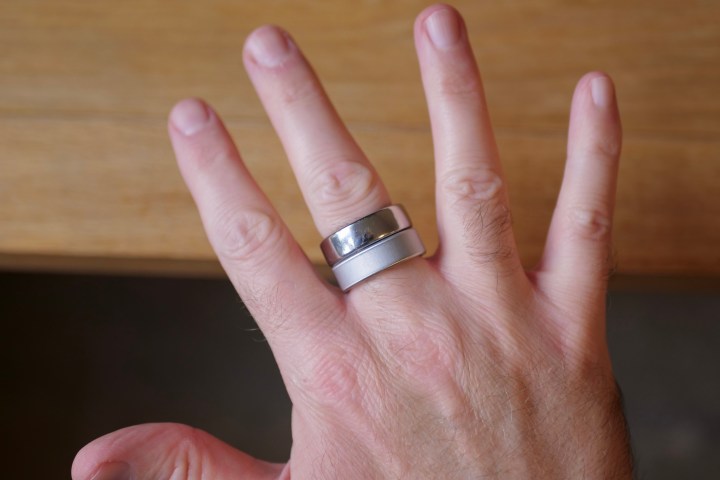 A person wearing the Oura Ring 3 and Oura Ring 4.