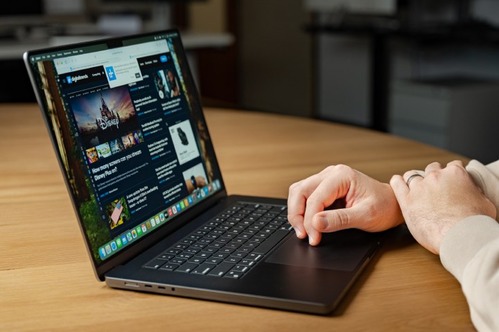 Someone using a MacBook Pro at a desk.