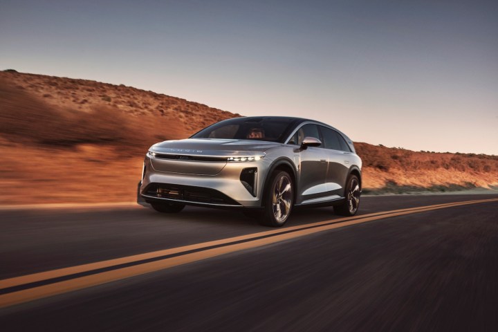 Alt: A Lucid Gravity electric SUV on a scenic road.