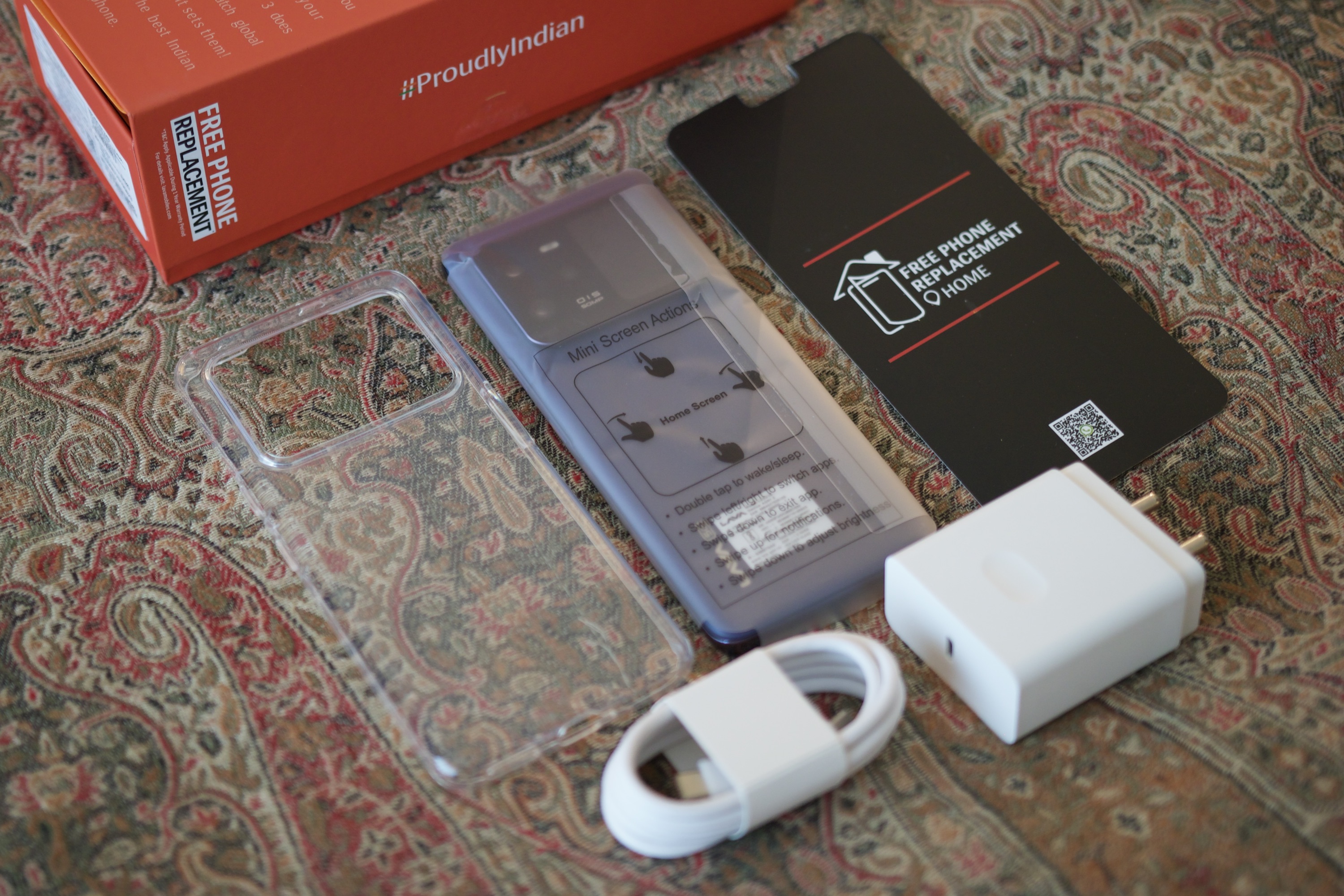 Alt: The contents of the Lava Agni 3 retail box, including the phone, a protective case, a 66W charger, and a charging cable.