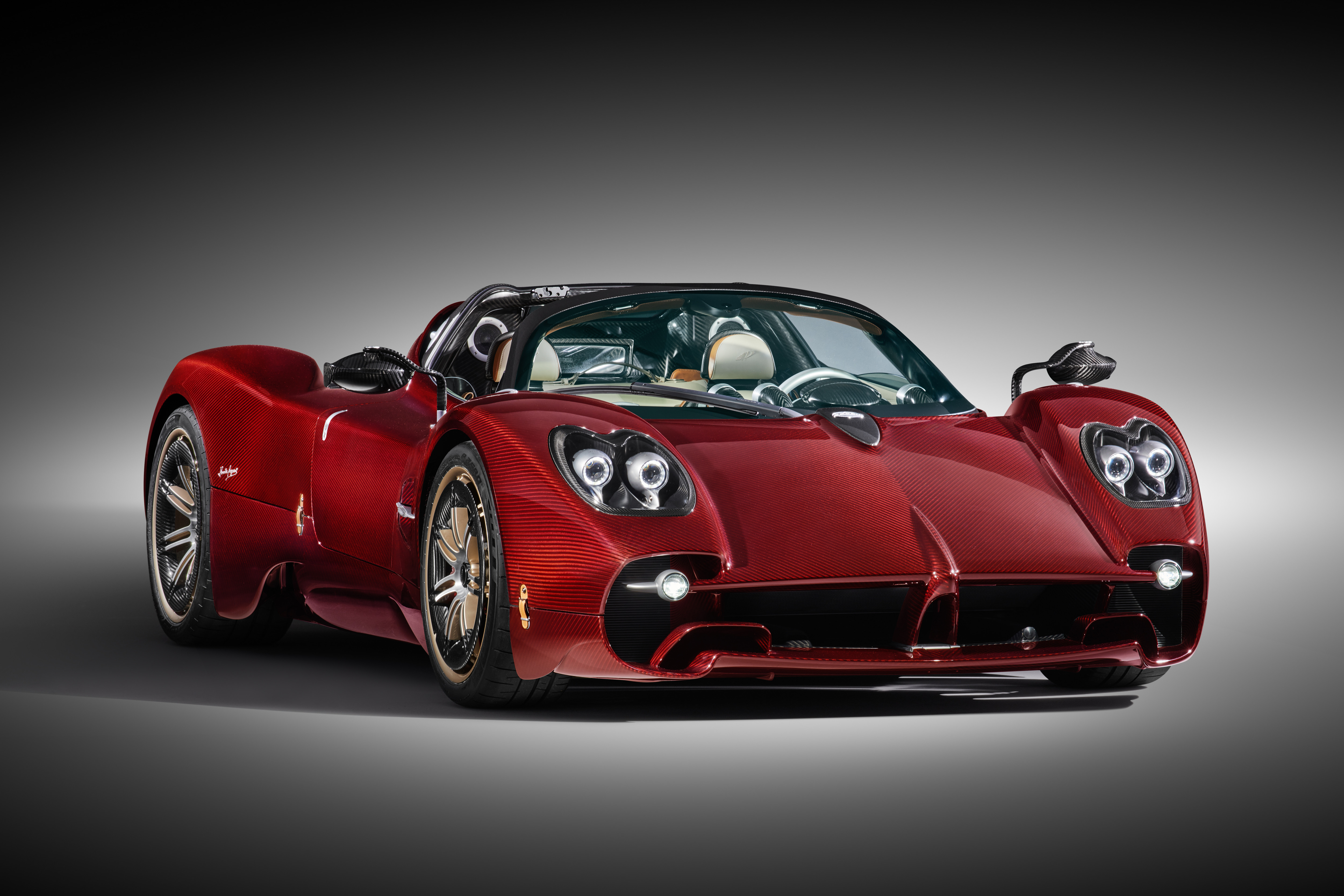 Red Pagani Utopia Roadster in a spotlight on a white background