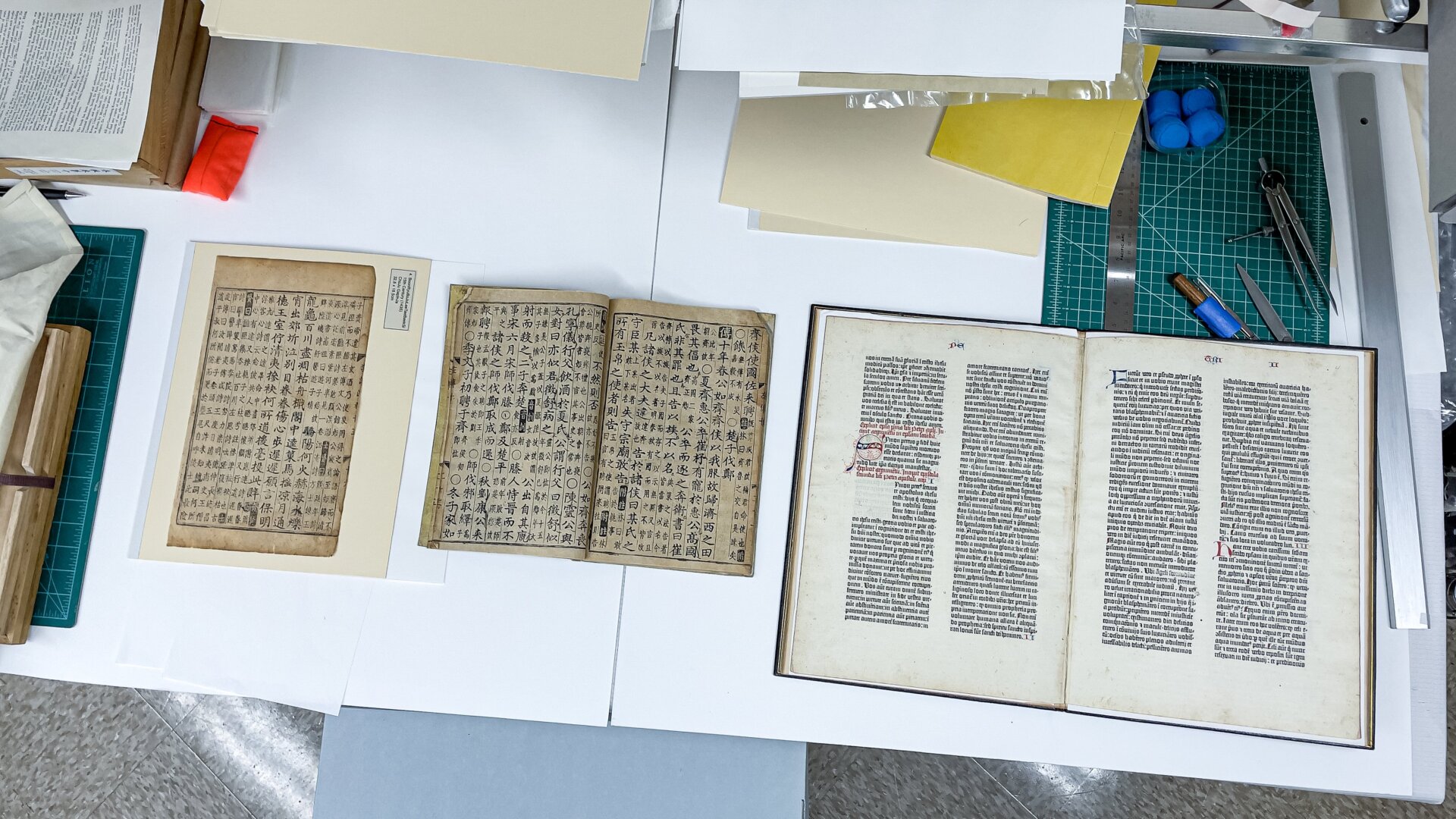 Two Korean documents and leaves of the Gutenberg Bible side-by-side at SLAC.