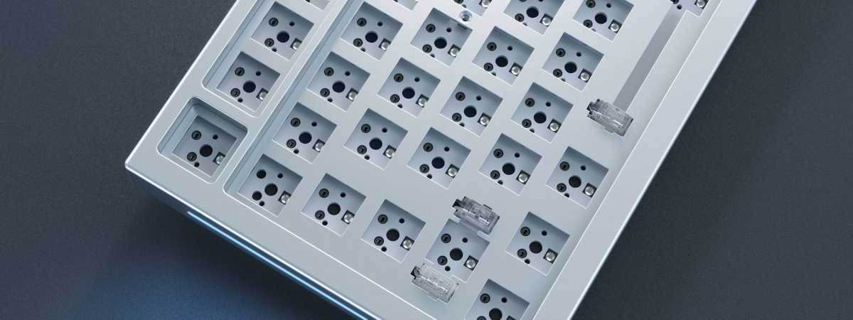 alt: Close-up of hot-swap sockets on a keyboard PCB, accommodating both 3-pin and 5-pin switches. The connectors facilitate the connection to the system.