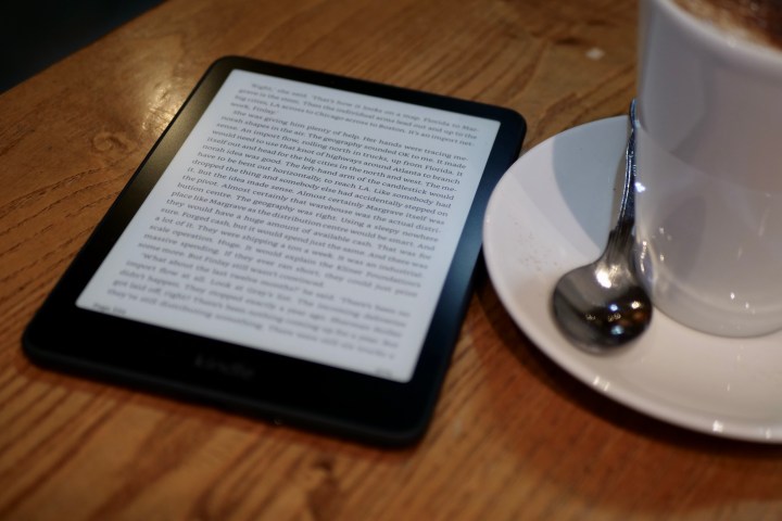 An Amazon Kindle Paperwhite 2024 next to a cup of coffee.