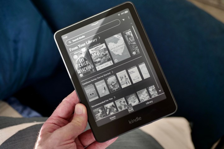 A person holding the Amazon Kindle Paperwhite 2024, showing the home page.