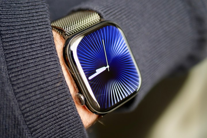 A person wearing the Apple Watch Series 10 in titanium with the Reflections watch face.