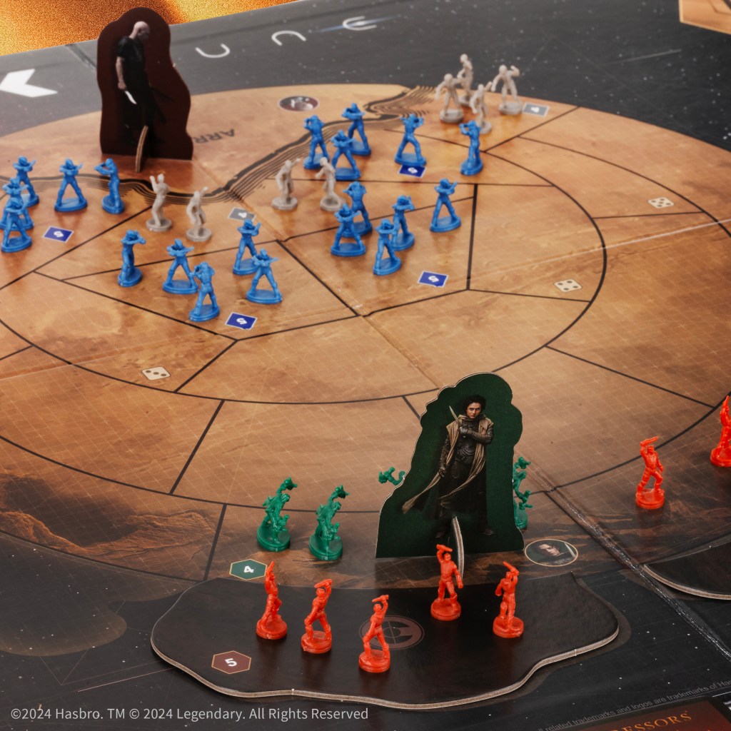 alt: Close-up view of various game components including command cards, dice, and tokens in Risk: Dune.