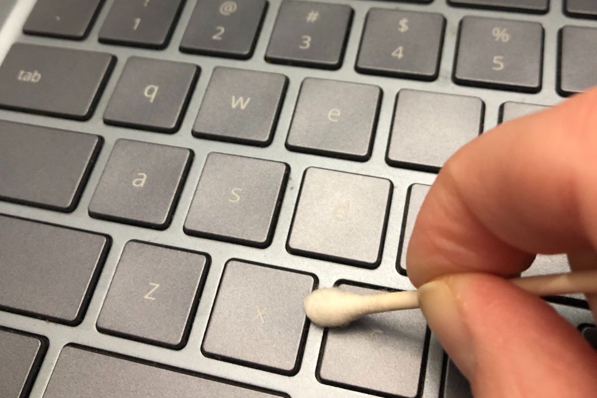 Cleaning laptop crevices with a cotton swab