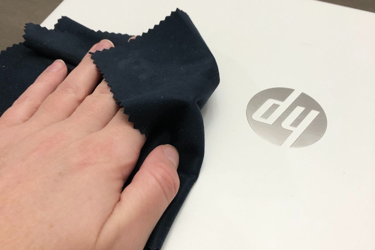 Wiping a laptop with a microfiber cloth