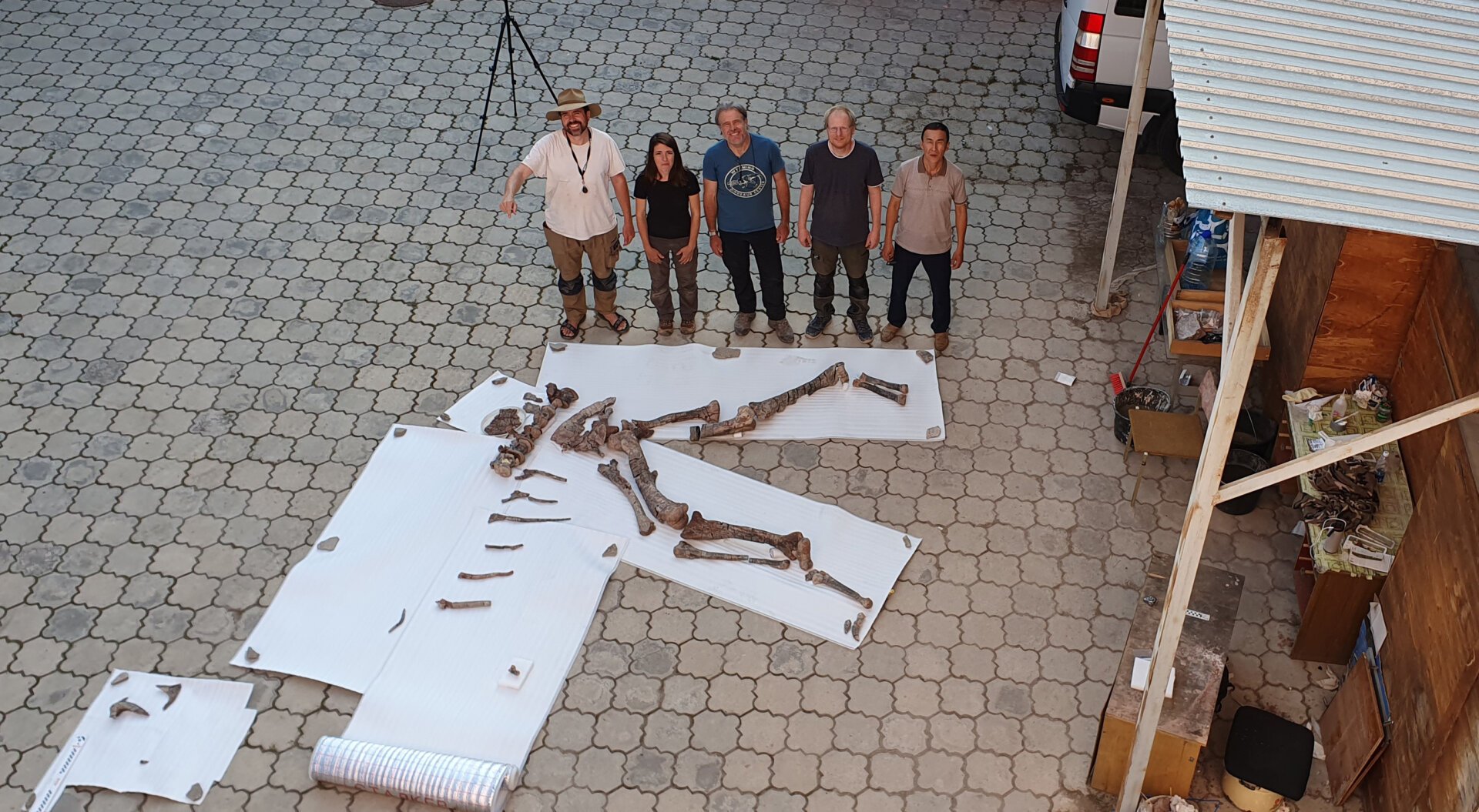 Photo of researchers posing with Alpkarakush kyrgyzicus fossils