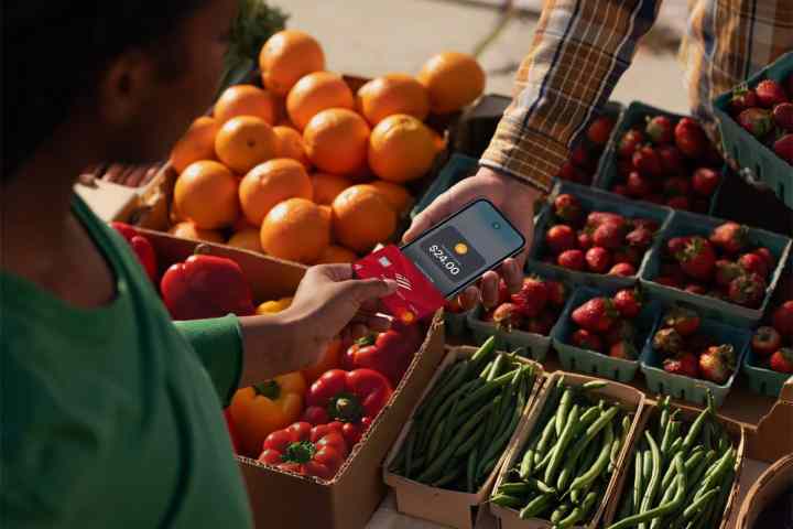 Person tapping a contactless payment card on an iPhone.