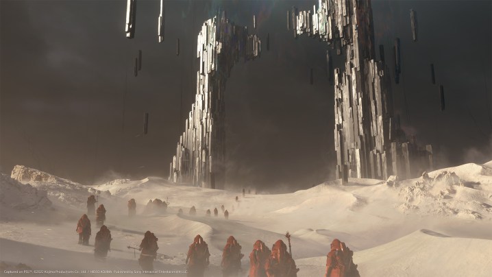 Hooded figures traversing a desert landscape.