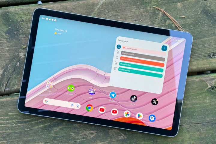 alt: The Google Pixel Tablet displaying its interface outdoors.