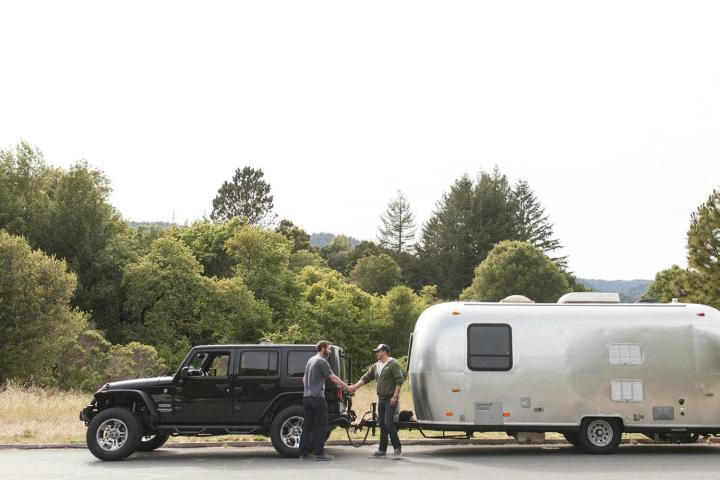 alt text: A family standing in front of a campervan, ready for their road trip adventure