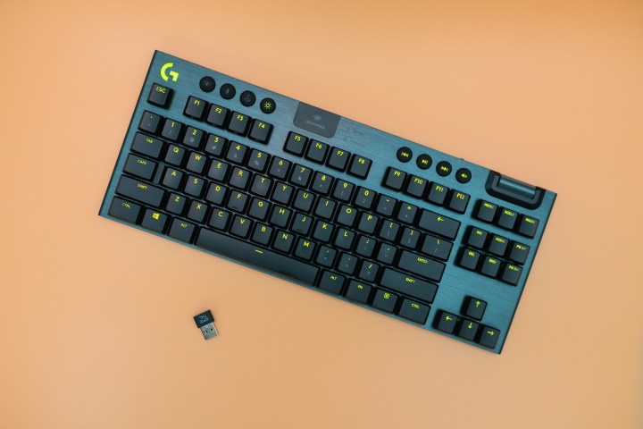 alt text: Logitech G915 TKL keyboard on an orange background. This tenkeyless design is popular among gamers and typists for its compact size.