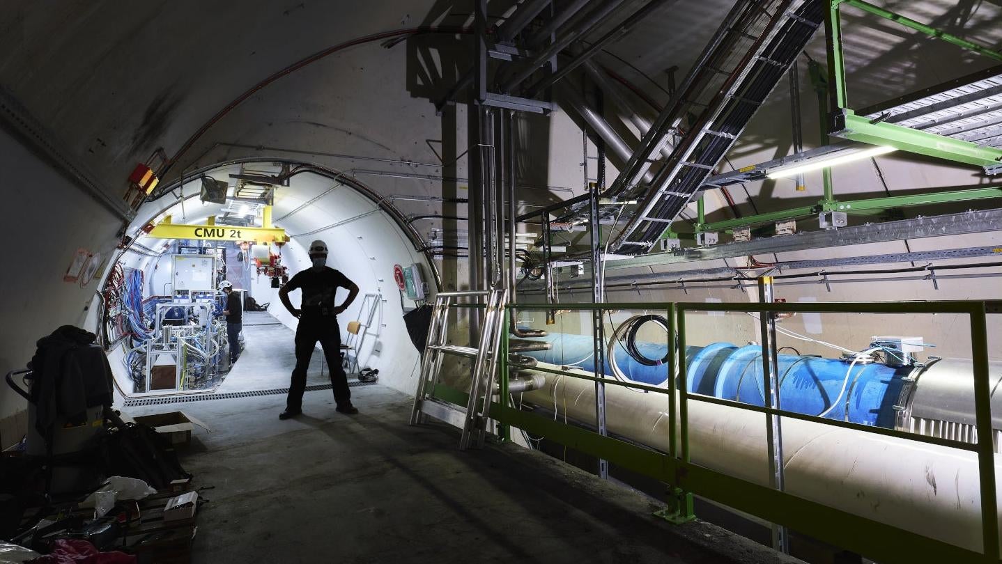 A worker stands in front of the FASER experiment at CERN.