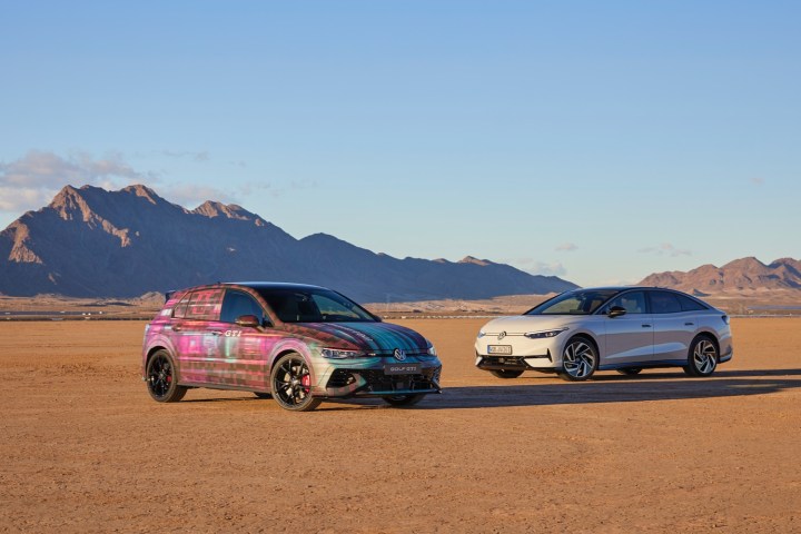 A Volkswagen Golf GTI in CES 2024 camouflage wrap and a Volkswagen ID.7 in the desert near Las Vegas.