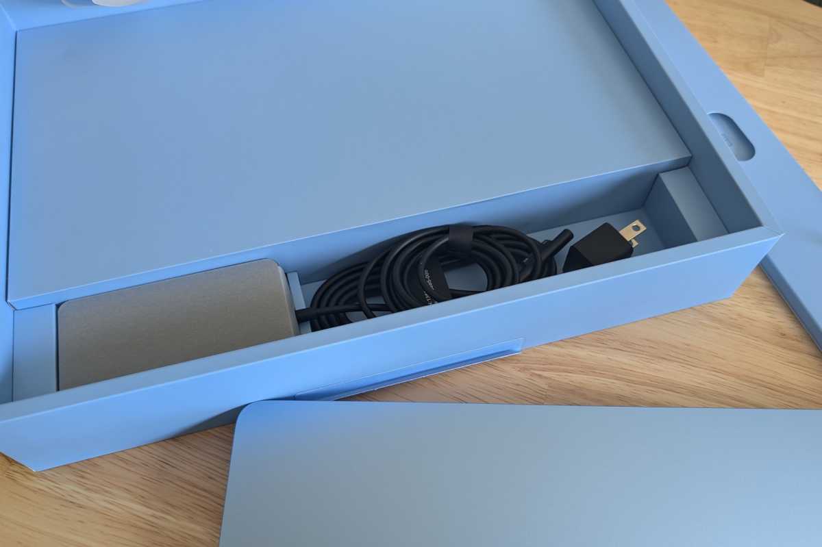 alt: Accessories included with a Surface Laptop, neatly organized in their original packaging.