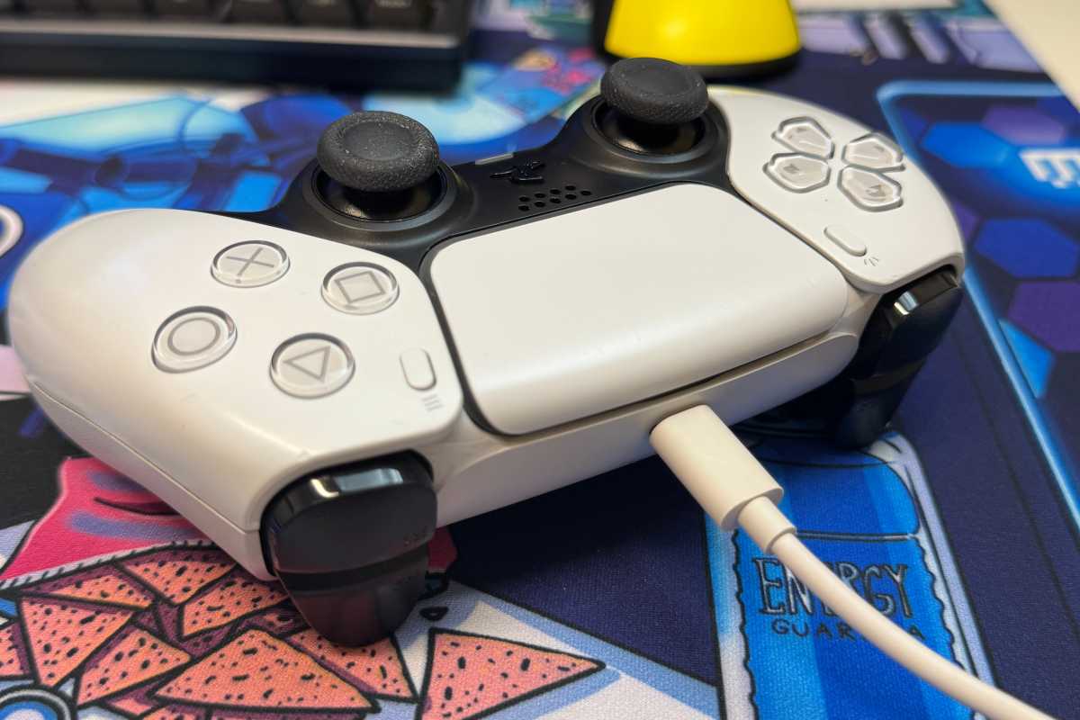 PlayStation DualSense controller with its USB cable plugged in