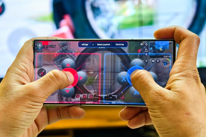 Redmagic 9S Pro Android gaming phone held in hands with virtual joystick for playing games like Call of Duty Mobile.